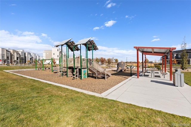 communal playground featuring a residential view and a lawn