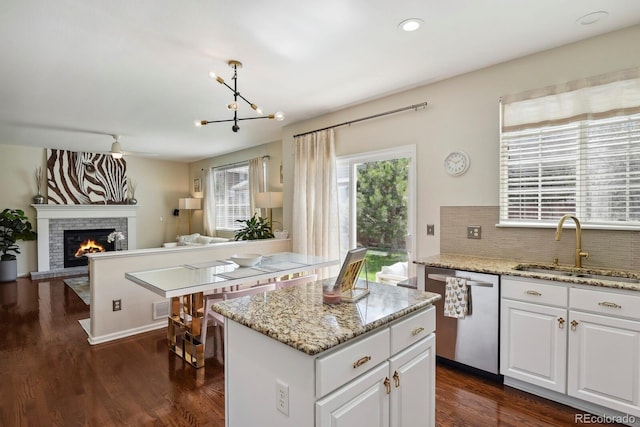 16164 E Hinsdale Ave, Aurora, CO 80016 - kitchen featuring a sink, a center island, open floor plan, tasteful backsplash, and stainless steel dishwasher