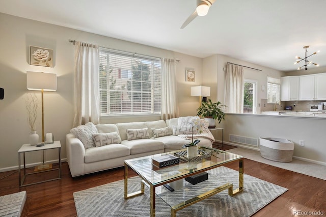 16164 E Hinsdale Ave, Aurora, CO 80016 - living room with baseboards, ceiling fan with notable chandelier, dark wood-style floors, and visible vents