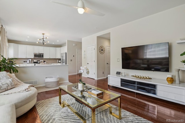 16164 E Hinsdale Ave, Aurora, CO 80016 - living area featuring visible vents, baseboards, recessed lighting, dark wood-type flooring, and ceiling fan with notable chandelier