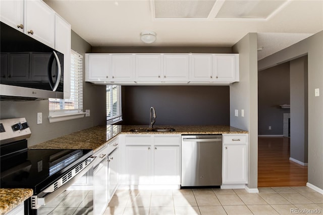 kitchen with white cabinets, appliances with stainless steel finishes, and light tile patterned floors