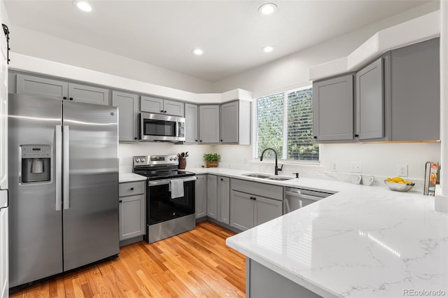 7600 W Coal Mine Ave Unit B, Littleton, CO 80123 - kitchen featuring stainless steel appliances, gray cabinets, light stone counters, recessed lighting, and light wood-type flooring