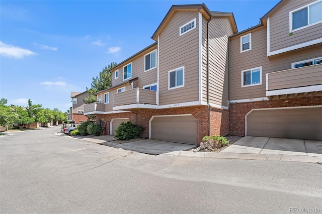 7600 W Coal Mine Ave Unit B, Littleton, CO 80123 - view of front of house featuring brick siding, an attached garage, and concrete driveway