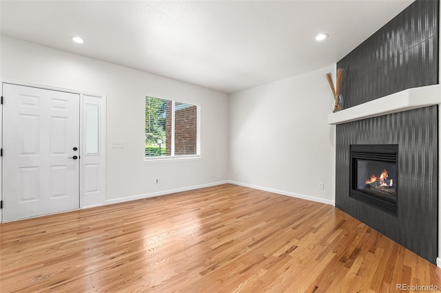7600 W Coal Mine Ave Unit B, Littleton, CO 80123 - unfurnished living room with light wood-type flooring, a large fireplace, and recessed lighting