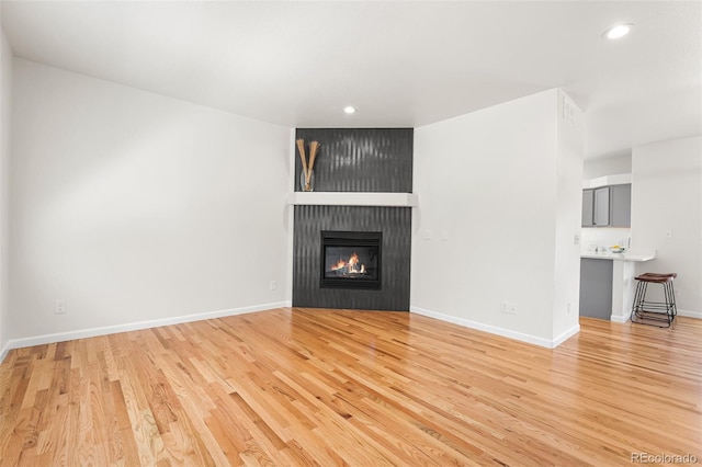 7600 W Coal Mine Ave Unit B, Littleton, CO 80123 - unfurnished living room featuring recessed lighting, light wood-style flooring, and a large fireplace