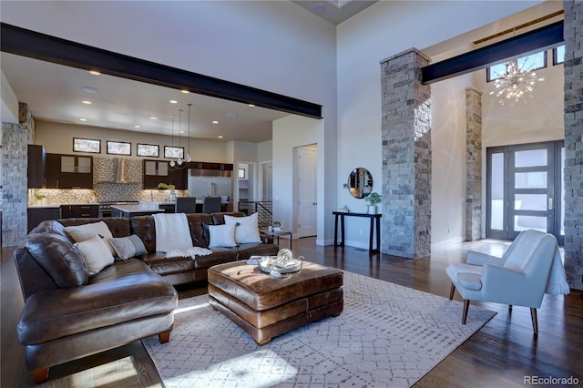 living room featuring dark wood-type flooring, a high ceiling, and a wealth of natural light