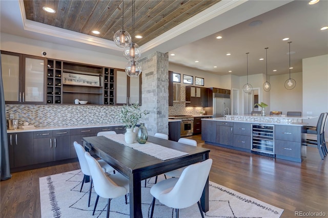 dining space featuring crown molding, dark hardwood / wood-style floors, beverage cooler, and a tray ceiling