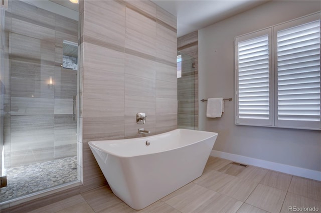 bathroom featuring tile patterned flooring and shower with separate bathtub