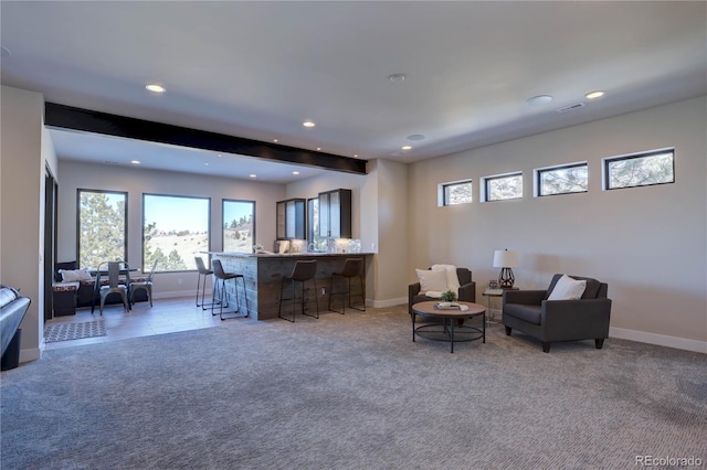 carpeted living room featuring bar and beamed ceiling