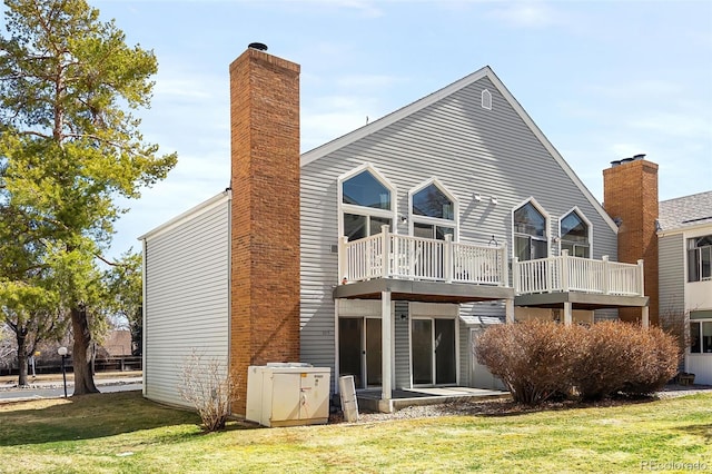 rear view of house featuring a lawn and a chimney