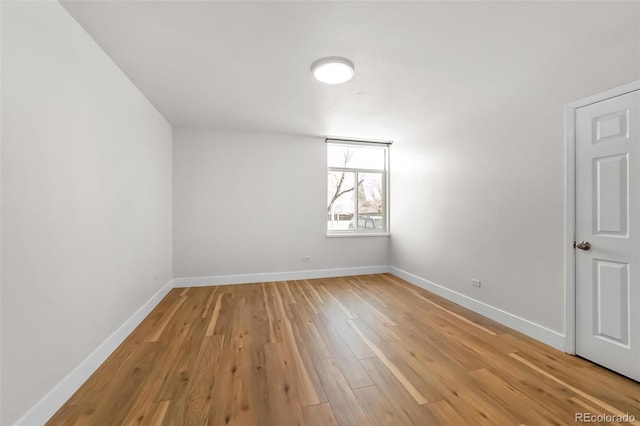 empty room with baseboards and light wood-style flooring