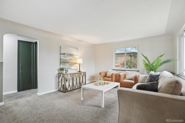 carpeted living room featuring baseboards