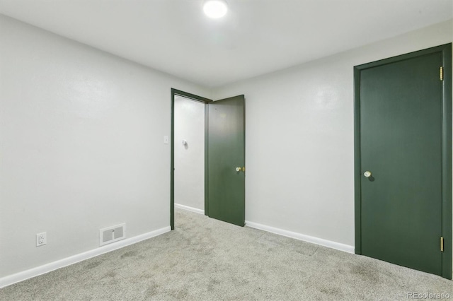 carpeted empty room featuring baseboards