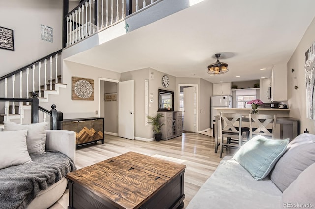 2890 W Long Cir Unit A, Littleton, CO 80120 - living room featuring light wood-style flooring and stairs