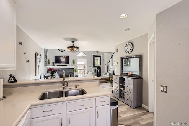 2890 W Long Cir Unit A, Littleton, CO 80120 - kitchen featuring open floor plan, white cabinets, light wood-style flooring, light countertops, and recessed lighting