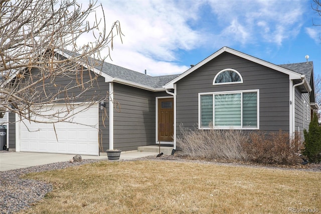 ranch-style house with driveway, an attached garage, roof with shingles, and a front yard