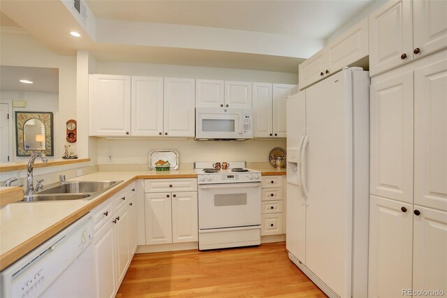 kitchen featuring light wood-type flooring, white appliances, white cabinetry, and sink