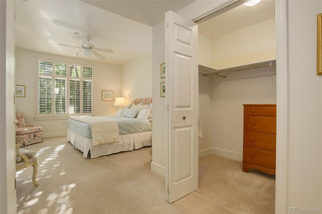 bedroom featuring light carpet, ceiling fan, and a closet