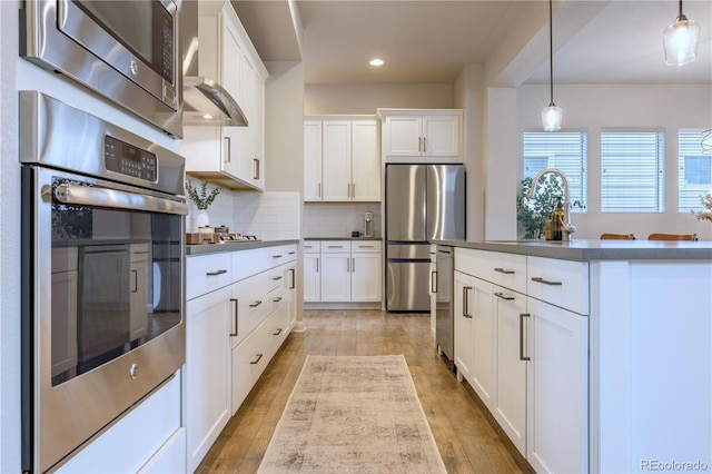 6682 Osage St, Denver, CO 80221 - kitchen featuring stainless steel appliances, a sink, decorative backsplash, light wood-type flooring, and recessed lighting