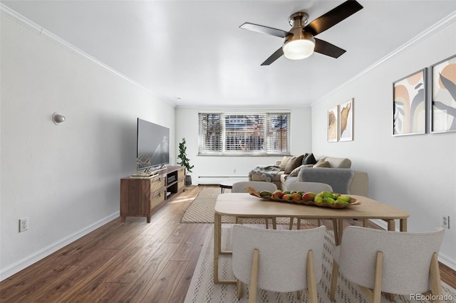 living room featuring ceiling fan, ornamental molding, hardwood / wood-style floors, and a baseboard heating unit