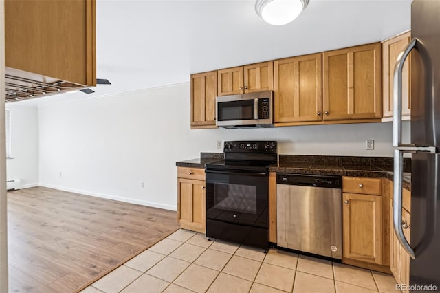 kitchen featuring light tile patterned floors, stainless steel appliances, and baseboard heating