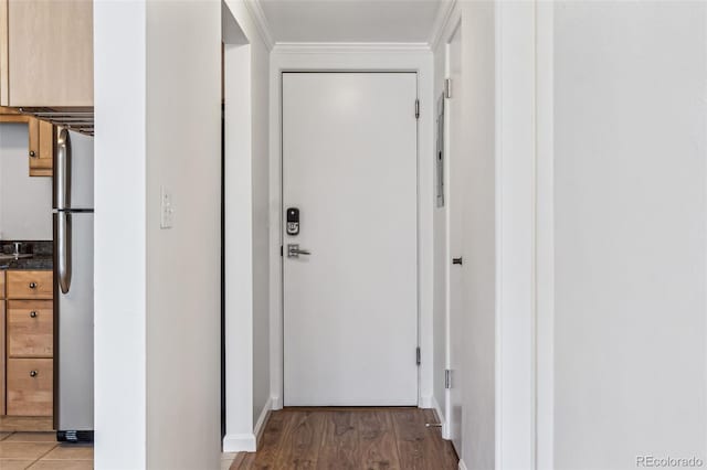 hall with ornamental molding and light wood-type flooring