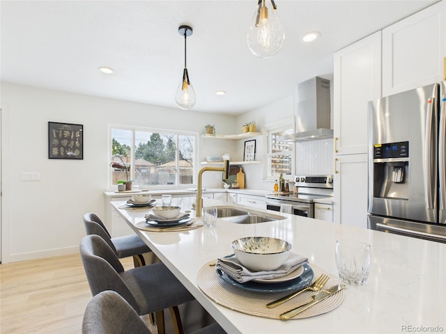 3150 S Pennsylvania St, Englewood, CO 80113 - kitchen with wall chimney exhaust hood, stainless steel appliances, light countertops, pendant lighting, and light wood-type flooring