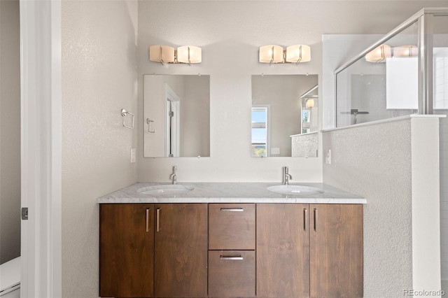 bathroom with vanity, toilet, and a shower with shower door