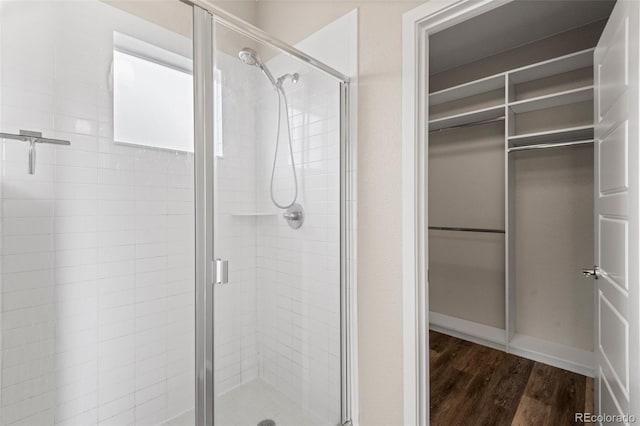 bathroom featuring hardwood / wood-style flooring and a shower with door