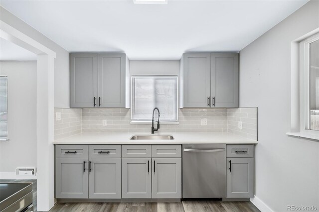 kitchen featuring gray cabinets, dishwasher, sink, and light hardwood / wood-style flooring