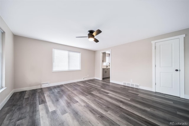 spare room with sink, dark hardwood / wood-style floors, and ceiling fan