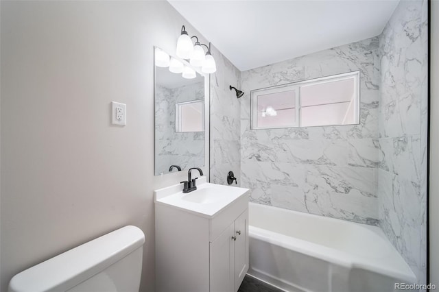 full bathroom featuring tiled shower / bath combo, vanity, and toilet