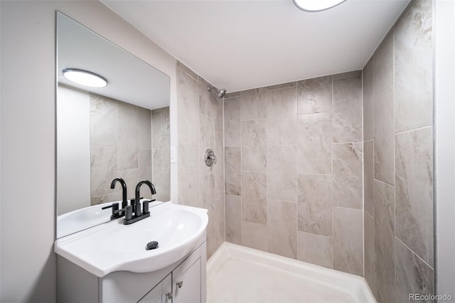 bathroom featuring tiled shower and vanity