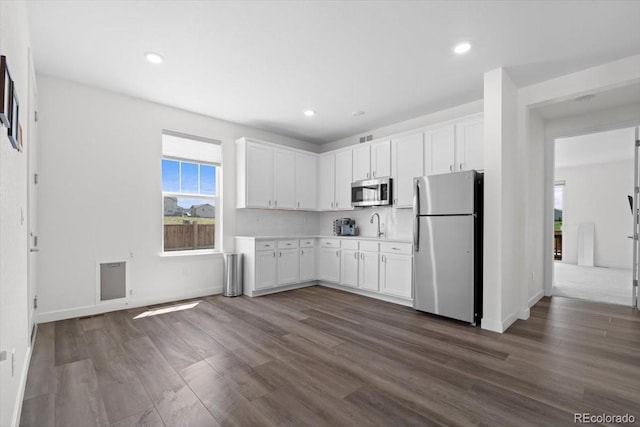 14601 Hudson St, Thornton, CO 80602 - kitchen with stainless steel appliances, light countertops, white cabinetry, dark wood-style floors, and recessed lighting