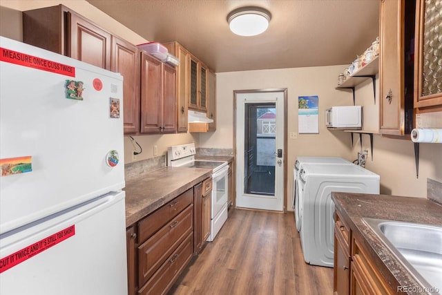 kitchen with dark wood-type flooring, white appliances, sink, and washer and dryer