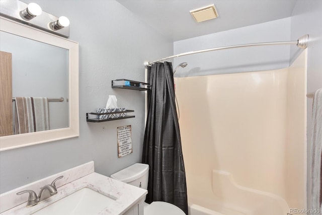 full bathroom with vanity, shower / bath combo, and toilet