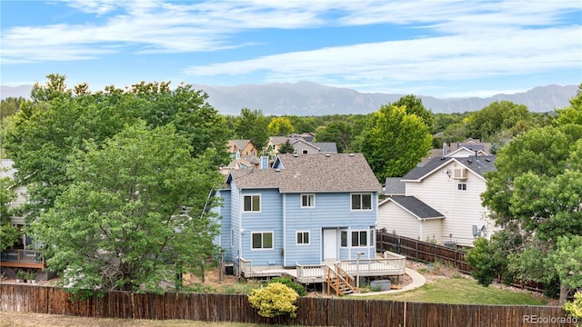1741 W 131st Ct, Denver, CO 80234 - back of property with a deck with mountain view, a fenced backyard, and a shingled roof
