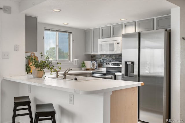 1741 W 131st Ct, Denver, CO 80234 - kitchen with stainless steel appliances, a peninsula, gray cabinets, a breakfast bar, and recessed lighting