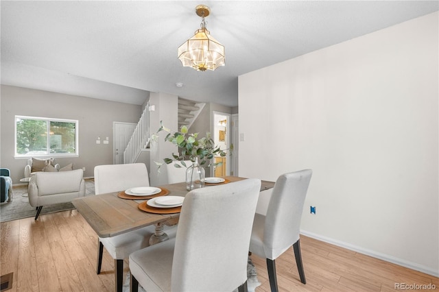 1741 W 131st Ct, Denver, CO 80234 - dining room with stairs, light wood finished floors, and a chandelier