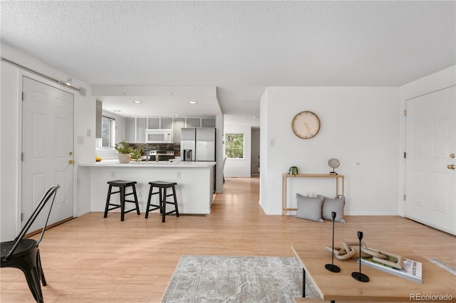 1741 W 131st Ct, Denver, CO 80234 - living area with light wood-style flooring, a textured ceiling, and recessed lighting