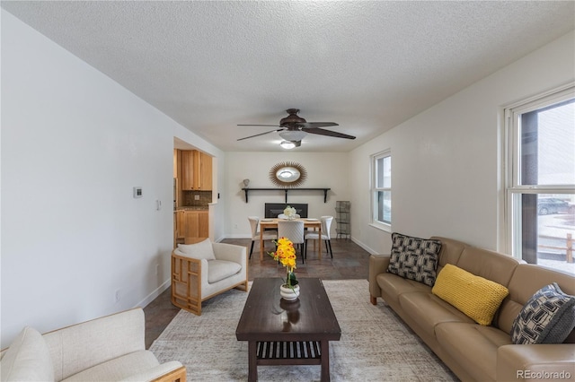 living room with ceiling fan and a textured ceiling