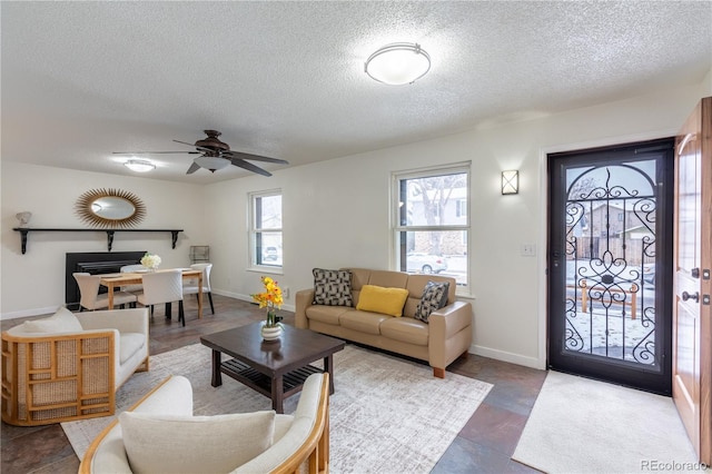 living room featuring ceiling fan and a textured ceiling