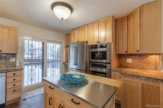 kitchen featuring tasteful backsplash, appliances with stainless steel finishes, and light brown cabinetry