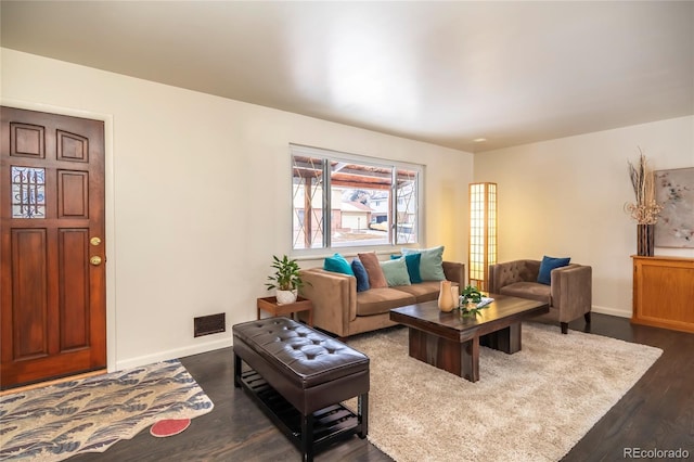 living room with baseboards, visible vents, and dark wood-type flooring