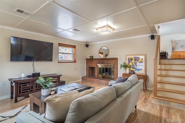 living area with light wood-type flooring, a fireplace, and visible vents