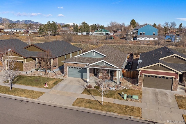 view of front of house with driveway, a residential view, a mountain view, and brick siding