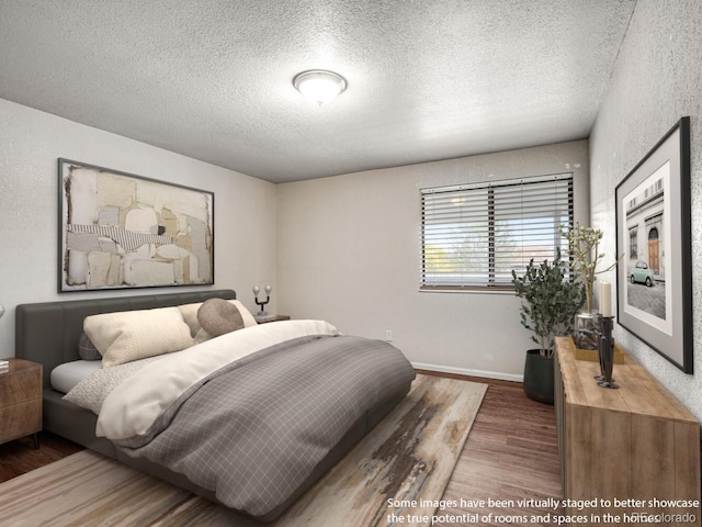 8335 Fairmount Dr Unit 9-206, Denver, CO 80247 - bedroom with baseboards, a textured ceiling, and wood finished floors