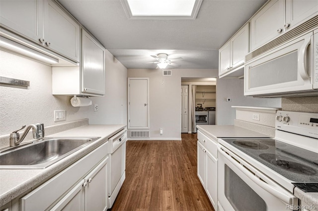 8335 Fairmount Dr Unit 9-206, Denver, CO 80247 - kitchen featuring washer and dryer, a sink, white cabinets, dark wood-style flooring, and white appliances