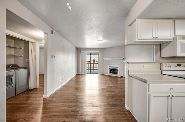 8335 Fairmount Dr Unit 9-206, Denver, CO 80247 - kitchen with white microwave, a textured ceiling, dark wood finished floors, separate washer and dryer, and open floor plan