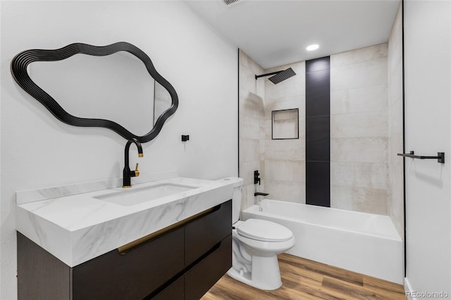 full bathroom featuring vanity, toilet, tiled shower / bath, and wood-type flooring